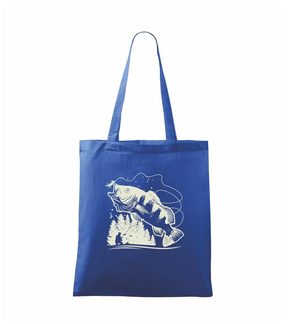 Rybář na břehu rybníka muškaří